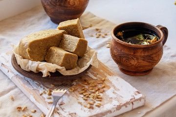 Homemade tasty semolina halva with whole almonds cut in squares on wooden board. Traditional Indian sweets