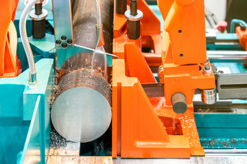 Round shaft steel is being cutting by automatic continuous and high speed horizontal band saw machine for industrial with the coolant fluid