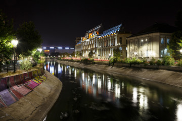 Fototapeta na wymiar Bucharest, Romania. Palace of Justice in downtown at night, with Dambovita River in front