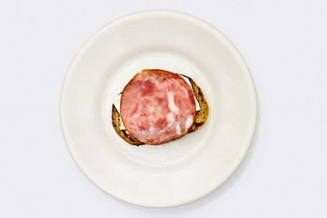 sandwich of bread, cheese and ham on a white plate isolated on white background