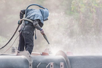 Sand blasting process, Industial worker using sand blasting process preparation cleaning surface on...