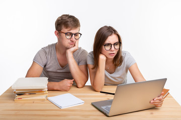 Education and people concept - couple of young people in glasses look like they are bored of...