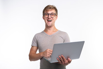 Emotions, education and people concept - a young handsome man looking in laptop and laughing