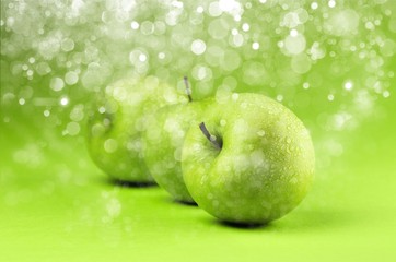 Row of green apples on green background