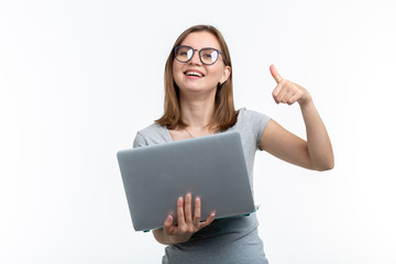 People and education concept - Attractive student woman holding a laptop and showing thumb up over white background