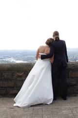 Bride and groom looking at a city from a high vantage point