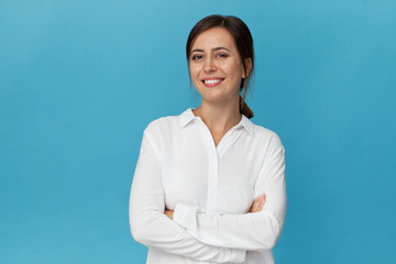 Businesswoman studio portrait. Confidence woman in elegant white shirt isolated on blue