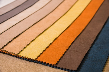 Colorful and bright fabric samples of leatherette furniture and clothing upholstery. Close-up of a palette of textile abstract stripes of different colors