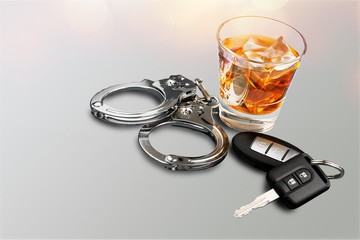 Whiskey with car keys and handcuffs concept for drinking and driving
