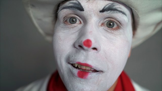 Very cute pantomime close up. Closeup portrait of a cute guy. A handsome guy mime smiles.