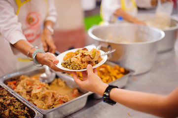 Poor people receiving food from volunteer : The concept of food donation