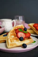 Breakfast Homemade Belgian waffles with berries on dark moody background