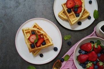 Homemade Waffles breakfast with berries syrup overhead view