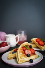 Breakfast Homemade Belgian waffles with berries on dark moody background