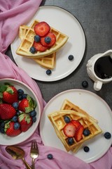 Homemade Waffles breakfast with berries syrup overhead view