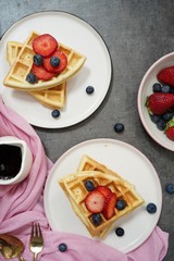 Homemade Waffles breakfast with berries syrup overhead view