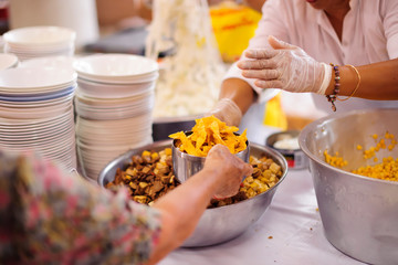 Volunteer food servers dish out a free charity : concept of helping