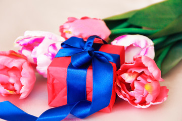 pink tulips and decorative gift box with a bow for the holiday of March 8