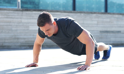 Young and sporty man training outdoor in sportswear. Sport, health, athletics.