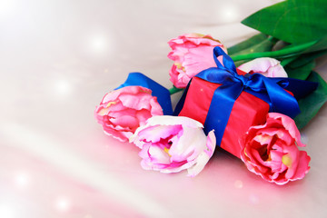 pink tulips and decorative gift box with a bow for the holiday of March 8