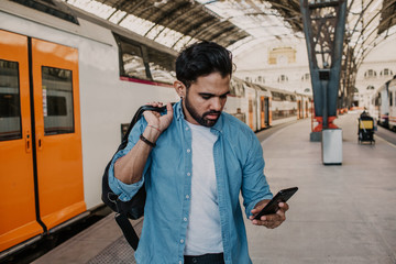 Attractive businessman sending message on his mobile phone.Casual professional entrepreneur using...