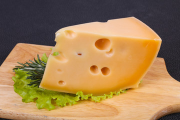 Maasdam cheese  in the board served salad leaves