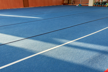 Colorful gym floor with diagonal color blocks. Background texture. Blue, black, white and yellow colors. Exercise concept, indoors sports, gymnastics. Bright cheerful.