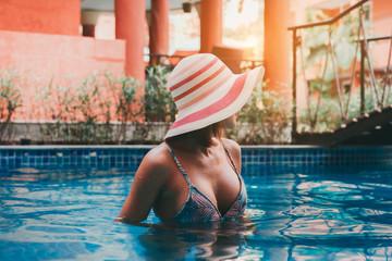 Portrait beautiful woman bikini swimming pool her sunbathe with sun hat relaxing vacation enjoying on tropical summer season.