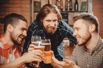 Group of bearded informal man plaid shirt drink draft beer in pub. Red brick wall background.