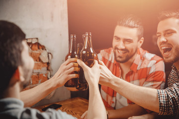 Cheerful male company drinks craft beer for meeting at bar. Concept leisure, friendship and celebration.