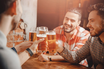 Company of happy friends in bar toast and clinking glasses beer. Concept male friendship