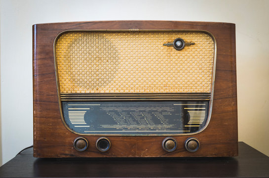 Old vintage radio on hardwood floor with warm background