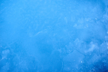Texture blue cosmic ice with a matte effect on a lake in the mountains.