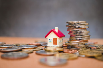 Miniature colorful house with stack coins using as property and financial concept