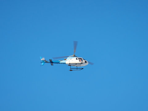 helicopter flies against the blue sky