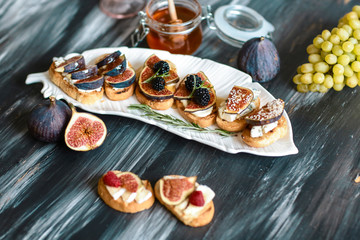 Presentation on wooden table bruschetta with cheese, figs and honey. concept of Italian cuisine
