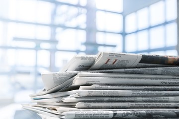 Pile of printed newspapers on white background