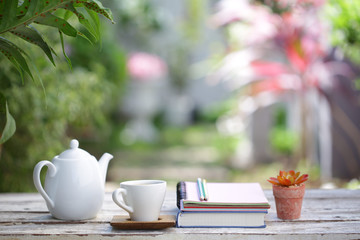 White kettle and cup with and notebooks