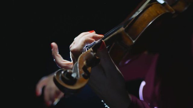 beautiful young girl playing the violin during the concert.close-up