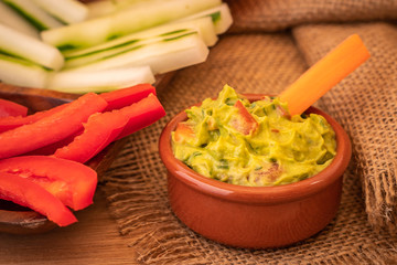 Guacamole con palitos de pimiento, pepino y zanahoria sobre arpillera