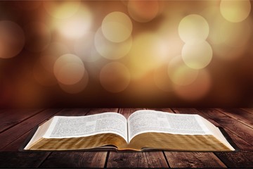 Open book on old wooden table.