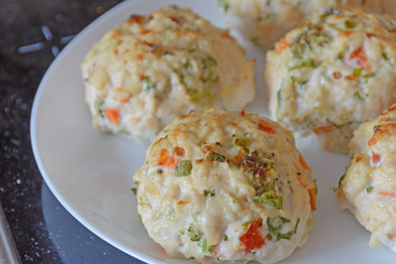 Chicken meatballs with vegetables - preparation for baked in the oven. Ingredients on the counter Healthy protein cutlets, minced cutlets. Proper, healthy food concept.