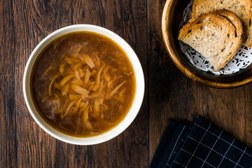 French Onion Soup with Bread on Dark Wooden Surface.