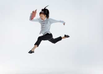 Fototapeta na wymiar Happy businesswoman dancing and smiling in motion isolated on white studio background. Flexibility and grace in business. Human emotions concept. Office, success, professional, happiness, expression