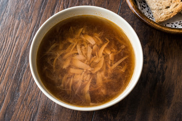 French Onion Soup with Bread on Dark Wooden Surface.