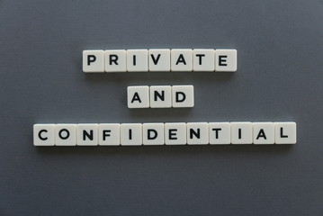 Private and confidential word made of square letter word on grey background.