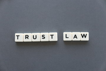 Trust law word made of square letter word on grey background.