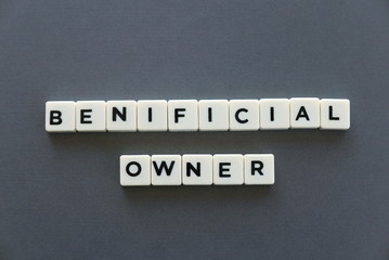 Beneficial owner word made of square letter word on grey background.