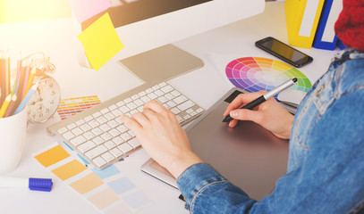 Young Handsome Graphic designer using graphics tablet to do his work at desk