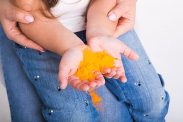 Festival of holi and holidays concept - baby's hand with colored powder.